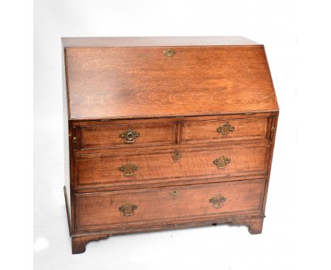 A crossbanded oak bureau with fitted interior above two short over two long drawers to bracket feet, width 111cm.