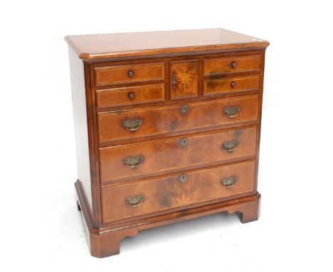 A walnut crossbanded media cabinet with hinged lid above three real and four dummy drawers raised on bracket feet, width 86cm