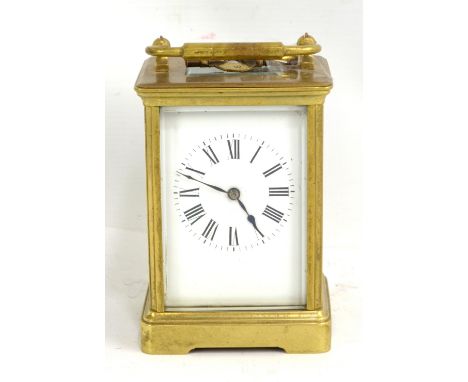 A circa 1900 French brass carriage clock with swing loop handle above rectangular white enamel dial set with Roman numerals, 