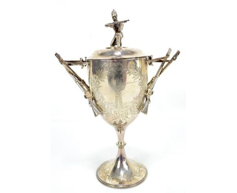 An unusual late Victorian hallmarked silver trophy cup and cover, the finial modelled as a kneeling soldier above an engraved