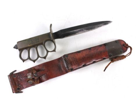 A US WWI period trench fighting knife with blackened blade, blade length 17.3cm, to brass hilt with rectangular section grip 