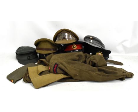 A group of military and military-type cloth caps, a blouse or tunic with Royal Artillery cloth badges and a khaki greatcoat w