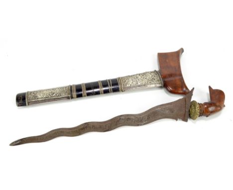 A Malayan kris with shaped pommel/grip, silvered metal embossed decoration to the scabbard and typical shaped blade, length 4