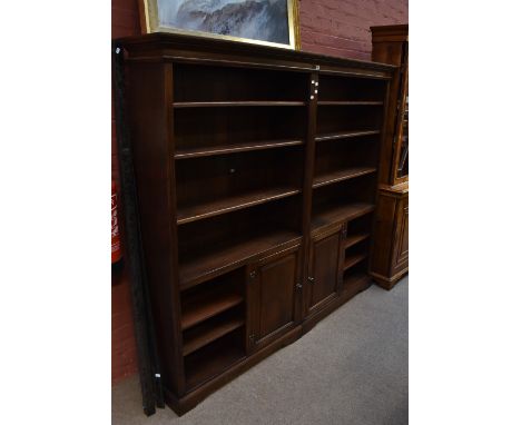 A reproduction solid oak two sectional bookcase, the upper sections with an assortment of adjustable shelves, above single pa