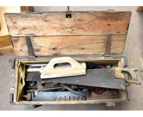 A vintage toolbox and tools, including a saw, drill, etc.