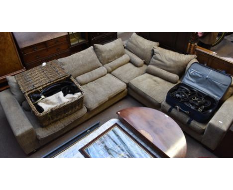 A large contemporary corner sofa, upholstered in a grey material, raised on stained wooden block supports, length 278cm.