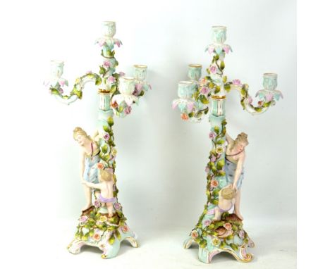 A pair of late 19th century three branch Sitzendorf figural candlesticks, with impressed marks to base, height 53cm.Additiona