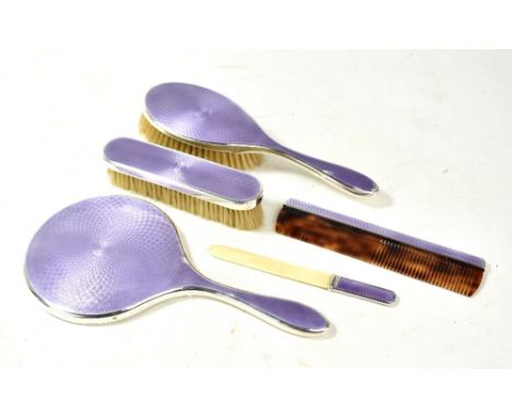 A George V hallmarked silver and purple guilloche enamelled five piece dressing table set comprising hand mirror, hair brush,