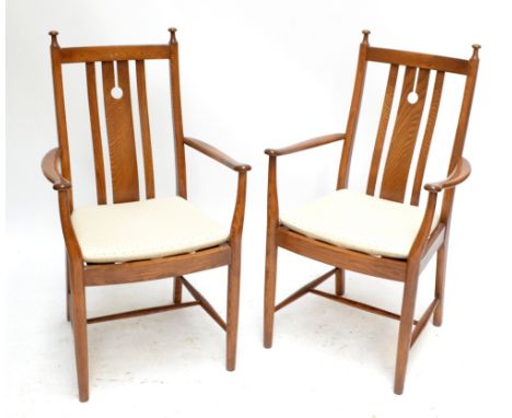 ERCOL; a pair of 'Golden Dawn' elbow chairs, with padded seats and turned front legs.