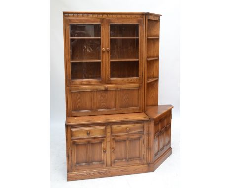 ERCOL; a 'Golden Dawn' display cabinet, with twin galzed doors above cocktail cabinet fall-front and base of two drawers and 