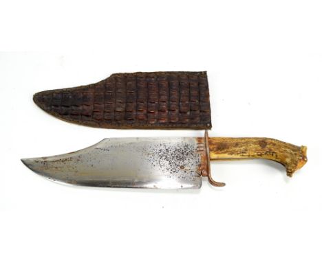 A massive vintage bowie knife with antler grip, shaped blade and leather scabbard, length 45.5cm.