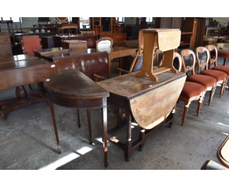 A 19th century oak drop leaf dining table of traditional design sold together with a 20th century light oak Sutherland style 