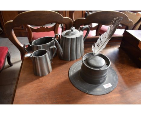 A 19th century pewter Capstan inkwell, and a pewter three piece tea set.