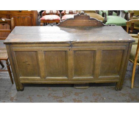 An 18th century oak four panel coffer, having a planked rectangular top over incised rails, the stile ends extending as feet 