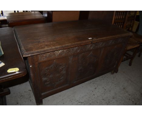 An 18th century oak three panel coffer,  of rectangular form with moulded edge decoration and later carved frieze and panels,