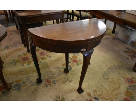 A 1920s demilune foldover card table raised on cabriole type supports terminating in claw and ball feet  79 CM X 91CM.