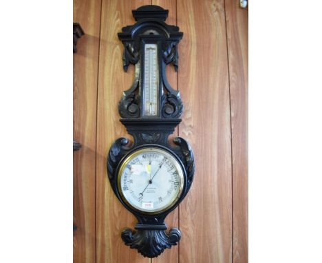 A Victorian carved and stained oak barometer, having thermometer scale over circular barometer dial, marked J.H Marlow Optici