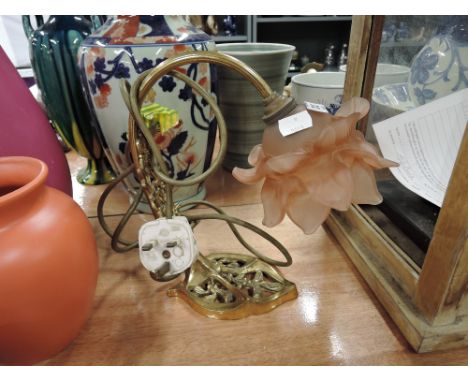 A vintage brass cast table lamp with pink glass flower shade