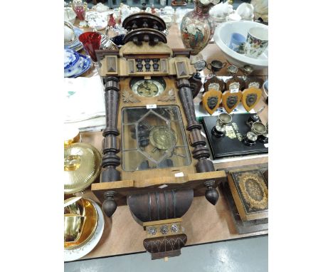 A vintage wall mounted clock with Victorian design and enamel face