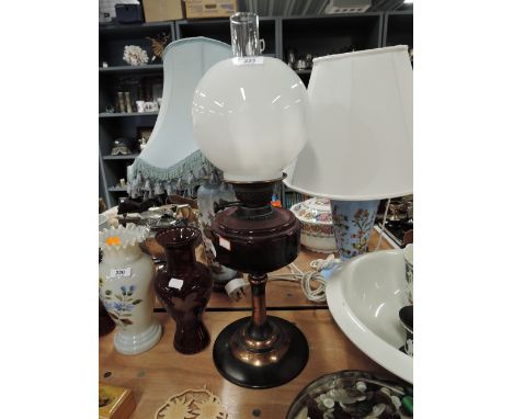 An oil lamp with red glass well milk glass shade and copper base