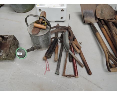 A selection of vintage garden tools and galvanised water can