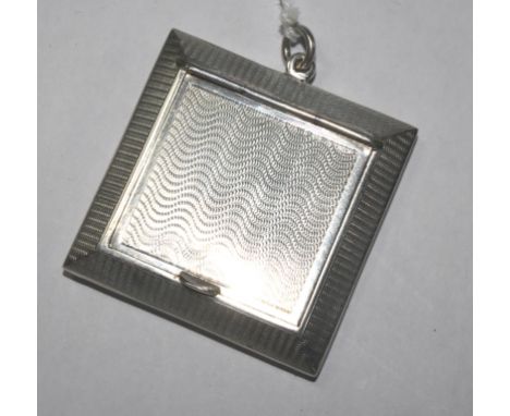 An engine turned sterling silver powder compact, London 1922, locking necklace pendant with gilt interior