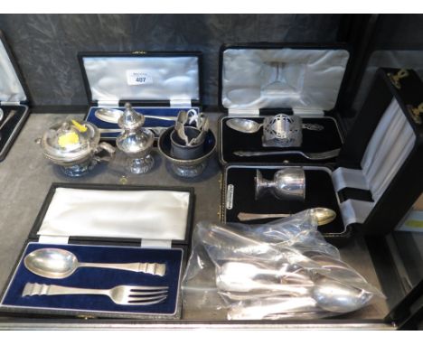 A collection of cased silver items to include egg cup and spoon, a childs fork, spoon and napkin ring, two cased fork and spo