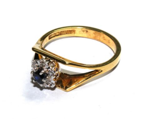 An 18 carat gold ring set with a diamond and sapphire cluster