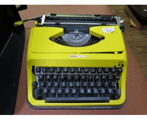 A yellow Antares 130 typewriter, and a Leitz Pradolux slide projector in original box (2)