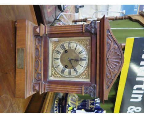 An early 20th century Hamburg America Clock Company walnut cased mantel clock, the arched shell carved and fluted pilaster ca