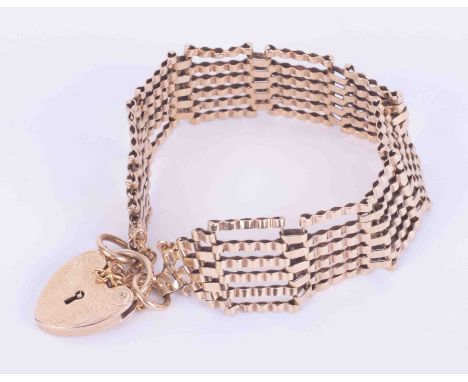 A 9ct yellow gold gate bracelet with engraved heart padlock and safety chain, 22.11gm.
