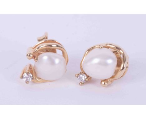 A pair of 9ct yellow gold stud earrings set with a white baroque pearl, surmounted by a gold swirl and a small round brillian