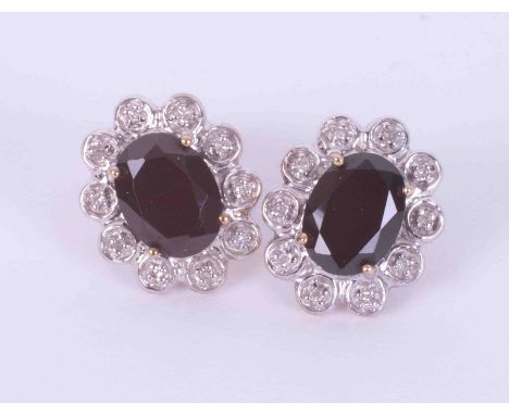 A pair of 9ct yellow &amp; white gold oval cluster earrings set with oval cut sapphires measuring 8mm x 6mm, surrounded by sm