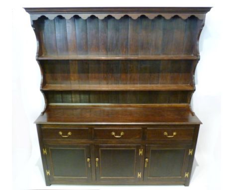 A Late 19th Early 20th Century Oak Dresser, the boarded shelf back above three drawers and three cupboard doors with brass sw