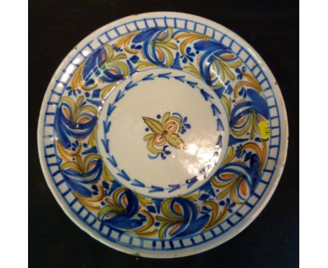 A 19th Century Delftware Deep Dish, decorated in polychrome enamels, the reverse marked in underglaze blue VMD, 34½ cms diame