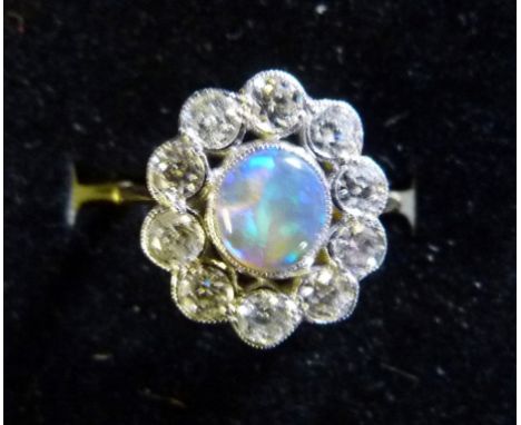 An 18ct. Yellow Gold Opal and Diamond Ring, with a central opal surrounded by diamonds within a pierced setting, approximatel