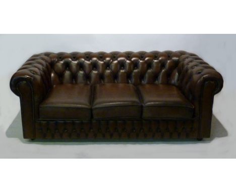 A Beige Leather Upholstered Chesterfield Type Sofa, with a button upholstered back and brass buttoned front, 190 cms wide