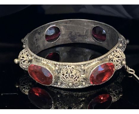 White metal bangle set with 4 large red stones Weight 49g 