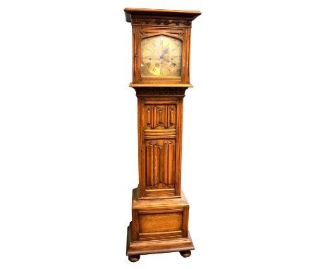 German oak longcase clock, the hood with moulded cornice, carved vine frieze and arched glazed door, eleven inch arched brass