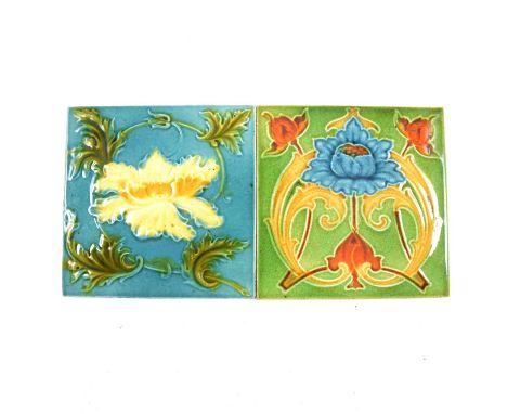 Two British Art Nouveau pottery tiles, each tubelined with stylised flowers, one with green ground, the other with turquoise 