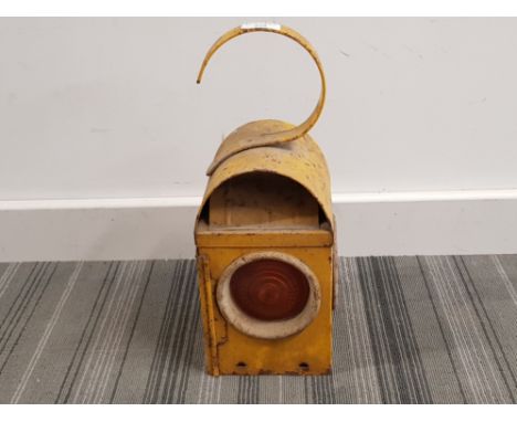 A yellow painted metal signal lamp.
