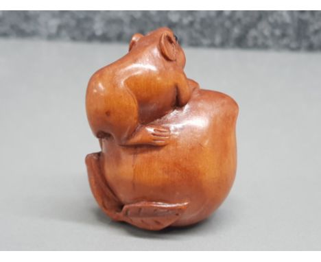 Handcarved hardwood Netsuke in the form of a field mouse on fruit