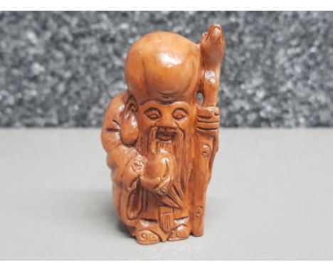 Handcarved hardwood Netsuke in the form of a village elder with staff