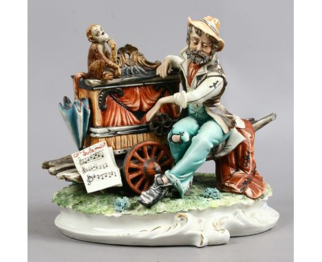 A Capodimonte figure of an organ grinder and monkey, signed Meneghetti.