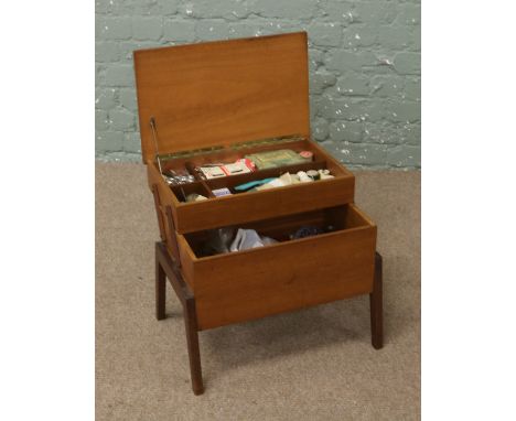 A light oak cantilever sewing box and contents of sewing equipment.