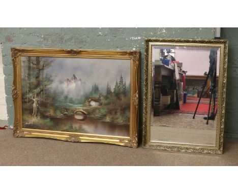 A gilt framed bevel edge wall mirror along with a gilt framed oil on canvas, woodland landscape with bridge to the foreground