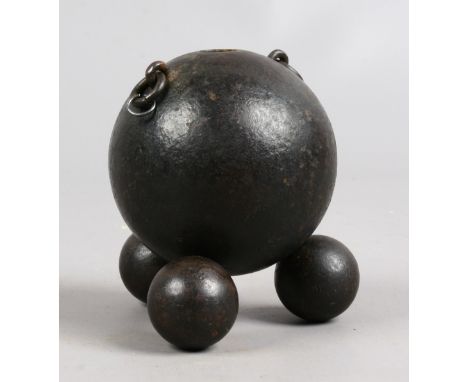 A novelty inkwell formed from a canon ball on smaller shot.