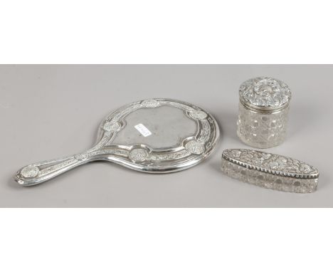 Three silver items, a silver backed hand mirror and two cut glass dressing table jars.