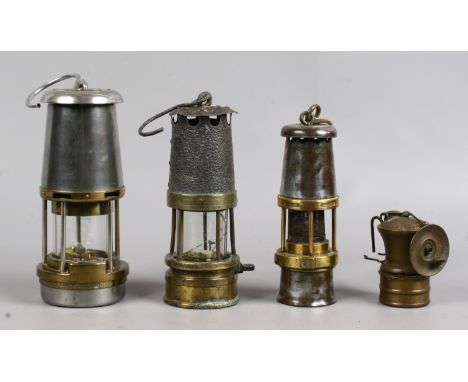 Four vintage miners lamps to include wolf, baby wolf, auto lite car lamp and an early example (glass cracked).