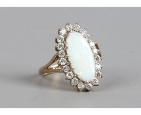 A 9ct gold ring with navette shape opal, halo set with white paste stones, size K1/2.